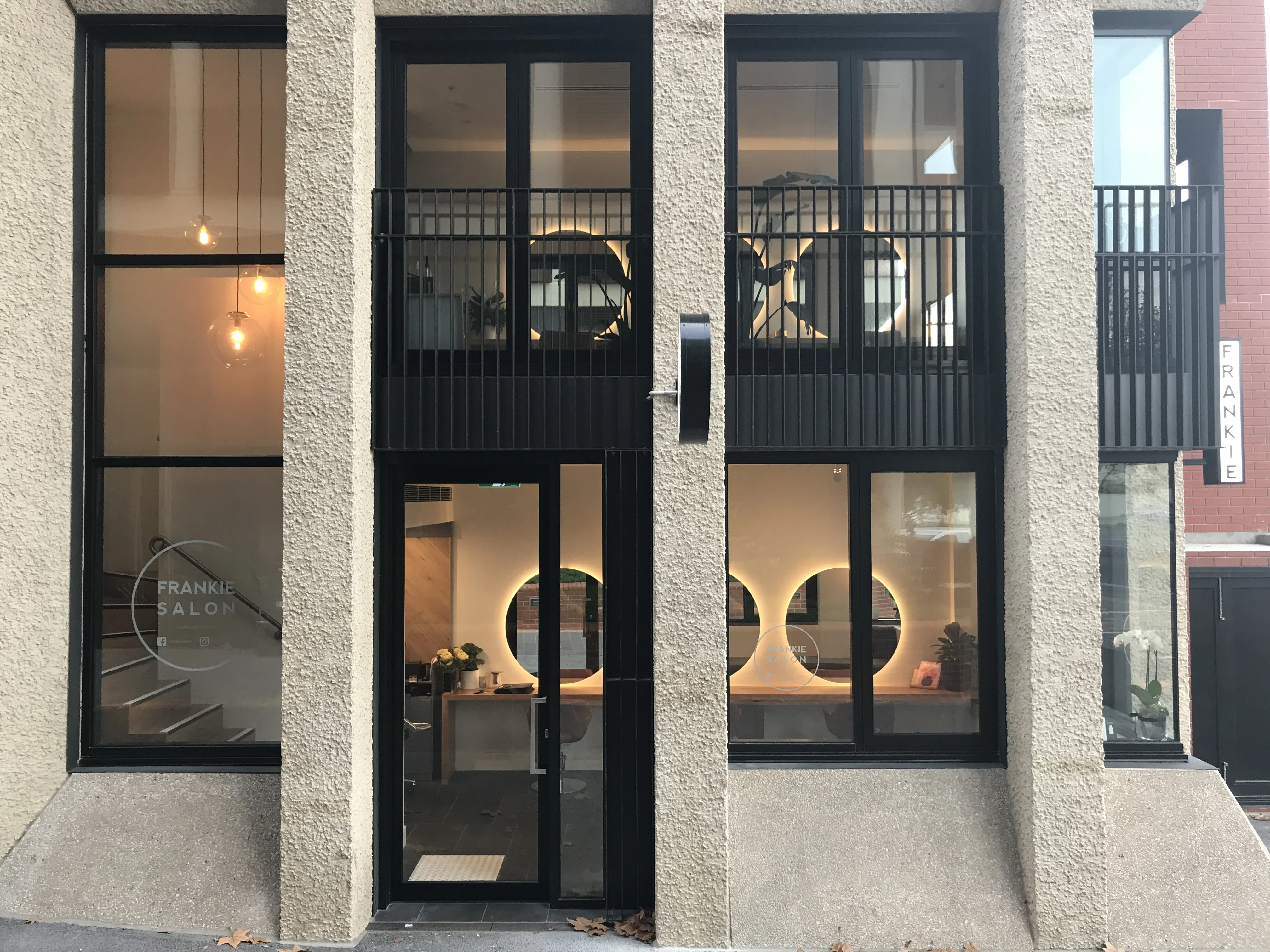Frankie Salon Richmond street facade with circular mirror glow through windows