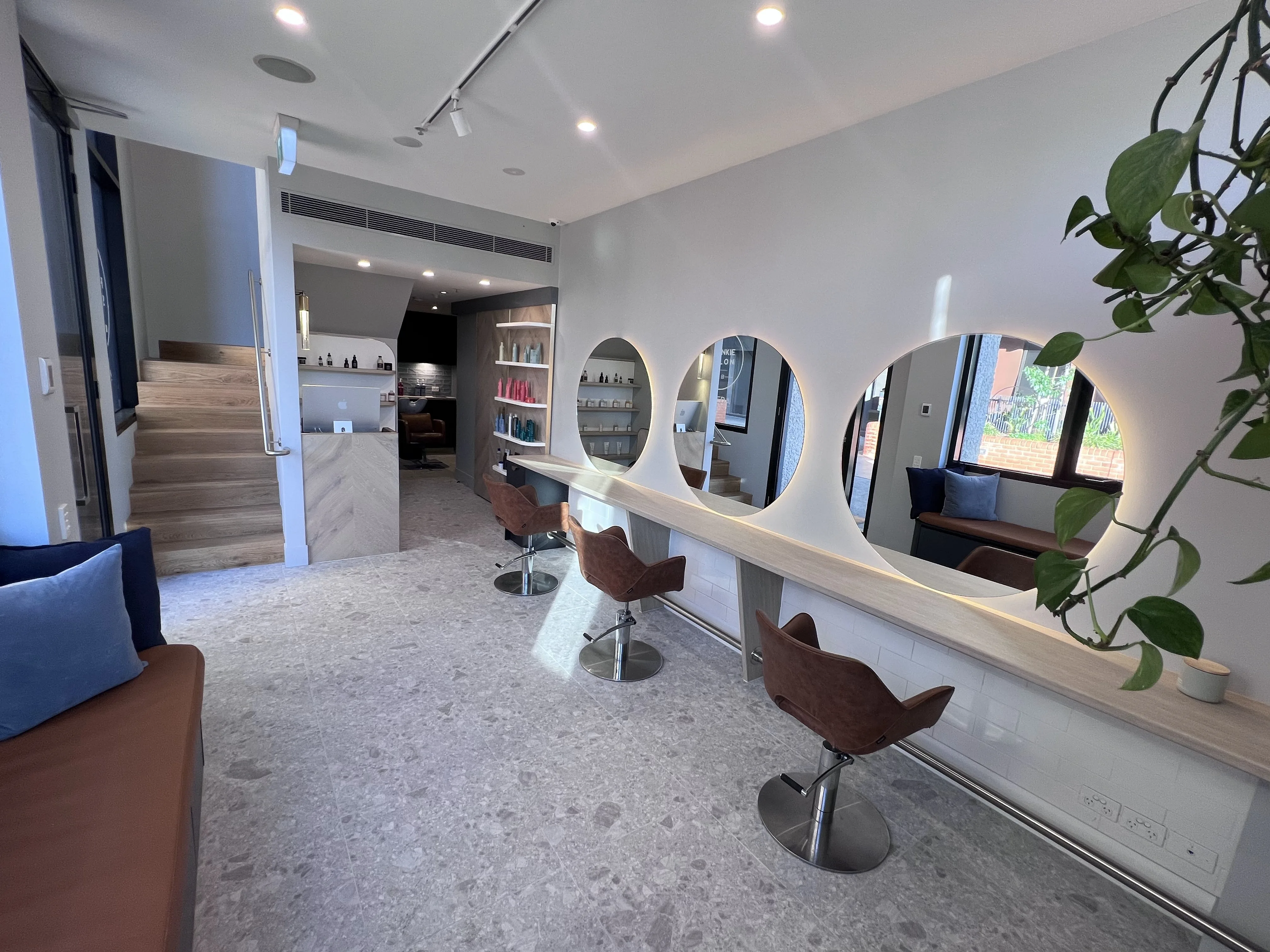 Frankie's empty styling row with timber staircase and terrazzo floor