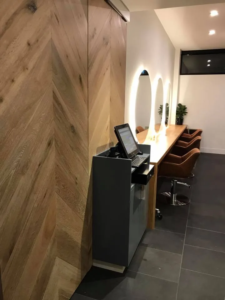 Frankie reception desk with chevron oak wall and lit oval mirrors