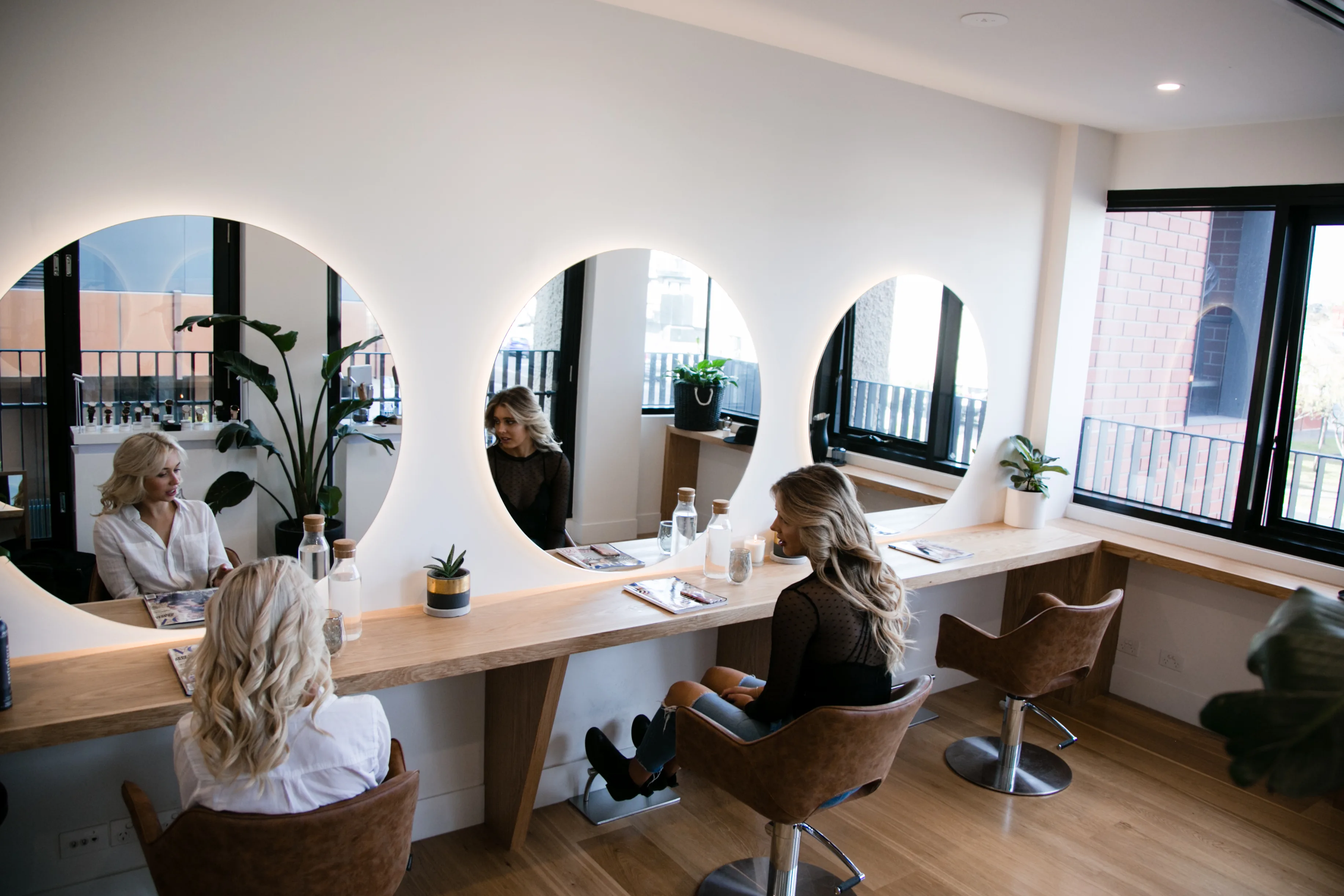 Clients at Frankie's circular-mirror relaxation bar in natural light